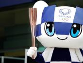 Tokyo 2020 Olympic Games mascot Miraitowa holds the torch of the Tokyo 2020 Olympic Games during a Torch Relay event to mark the 300-day milestone to the starting date of the torch relay, in Tokyo