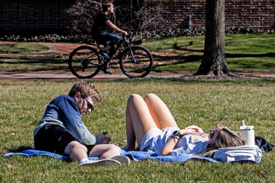 University of Delaware students enjoy a sunny and warm winter day on The Green in Newark, Thursday, Feb. 23, 2023.