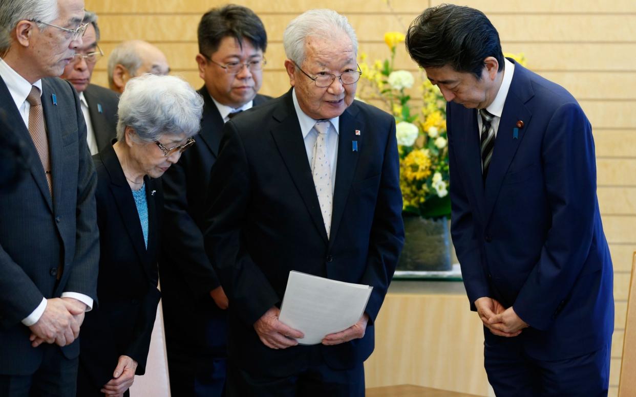 Japan's Prime Minister Shinzo Abe meets Shigeo Iizuka, leader of a group of families of Japanese abducted by North Korea - AFP