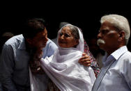 Aziz Shaikh (L), father of Sabika Aziz Sheikh, a Pakistani exchange student, who was killed with others in the shooting, comforts a relative in Karachi, Pakistan May 19, 2018. REUTERS/Akhtar Soomro