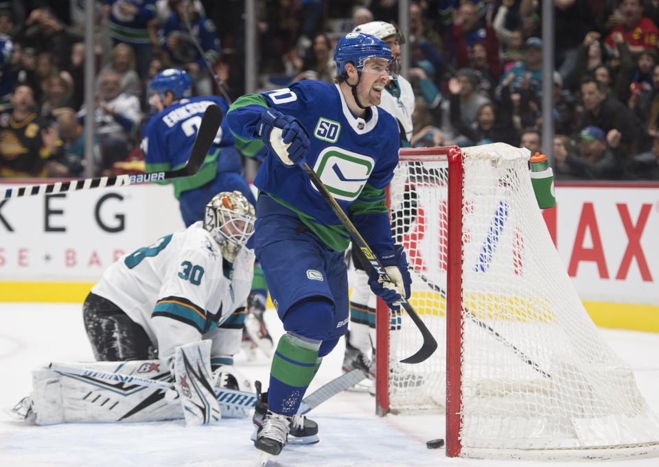San Jose Sharks goaltender Aaron Dell (30) gets up as Vancouver Canucks centre Brandon Sutter (20) celebrates a goal by Loui Eriksson during the second period of an NHL hockey game Saturday, Jan. 18, 2020, in Vancouver, British Columbia. (Jonathan Hayward/The Canadian Press via AP)