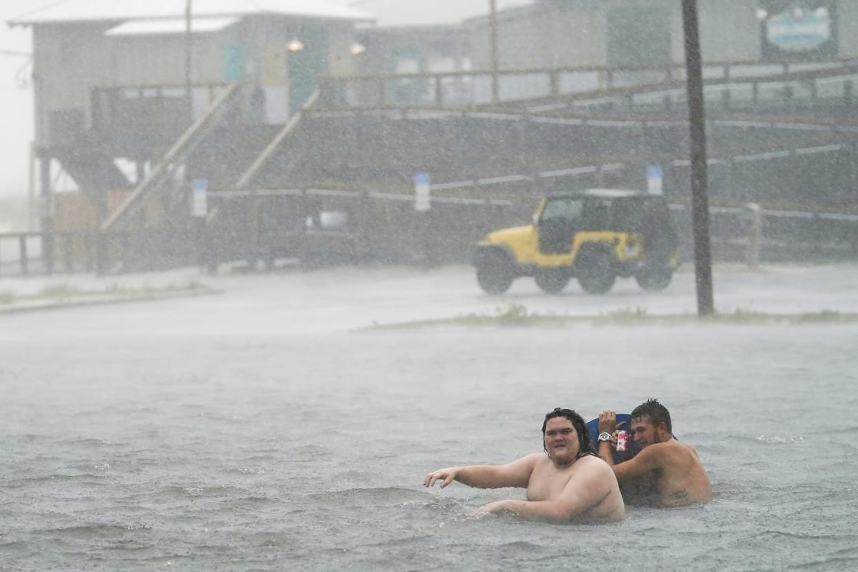 Image: People play in a flooded parking lot at Navarre Beach, Tuesday, Sept. 15, 2020, in Pensacola Beach, Fla. (Gerald Herbert / AP)