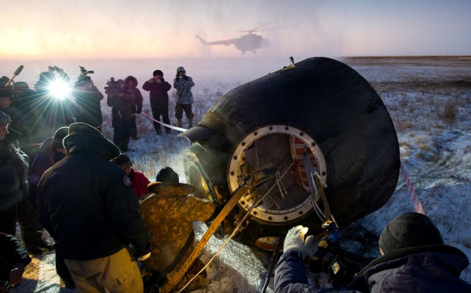 Russian support personnel work to help get Expedition 29 crew members out of the Soyuz TMA-02M spacecraft shortly after the capsule landed with Expedition 29 Commander Mike Fossum, and Flight Engineers Sergei Volkov and Satoshi Furukawa in a remote area outside of the town of Arkalyk, Kazakhstan, on Tuesday, Nov. 22, 2011. NASA Astronaut Fossum, Russian Cosmonaut Volkov and JAXA (Japan Aerospace Exploration Agency) Astronaut Furukawa are returning from more than five months onboard the International Space Station where they served as members of the Expedition 28 and 29 crews. Photo Credit: (NASA/Bill Ingalls)