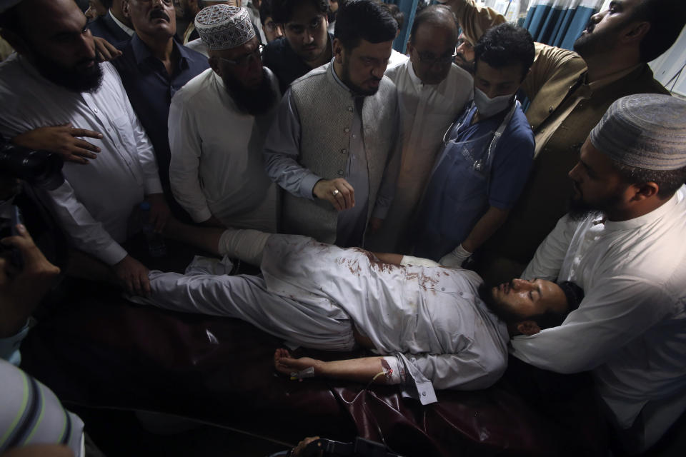 Relative of an injured victim of a powerful bomb stand around his bed at a hospital in Peshawar, Pakistan, Sunday, July 30, 2023. A bomb ripped through a rally by supporters of a hard-line cleric and political leader in the country's northwestern Bajur district that borders Afghanistan on Sunday, police and health officials said. (AP Photo/Muhammad Sajjad)