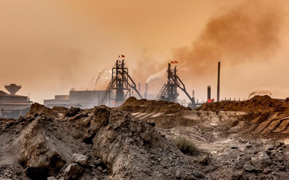 An industrial plant pollutes the air and produces hazardous waste in Baotou, Inner Mongolia, China. - Shutterstock