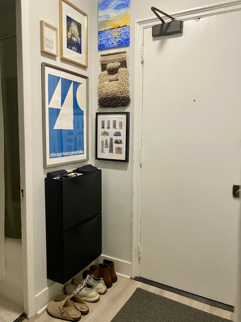 An entryway gallery wall with a storage shelf and shoe collection.