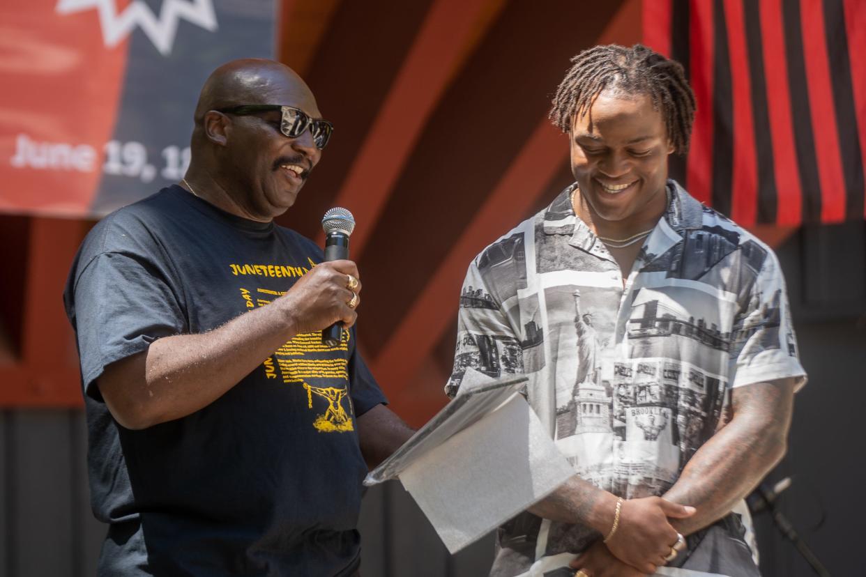 Tommy Meeks presents Lutheran High School graduate and NFL running back James Robinson with an award at Sinnissippi Park on Saturday, June 19, 2021, for his accomplishments on and off the field.
