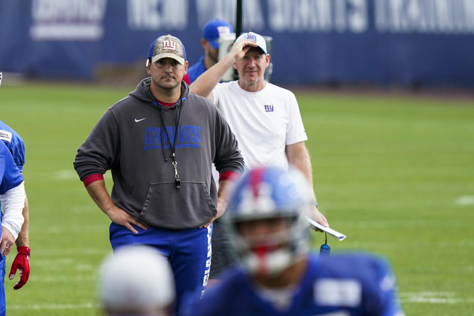 New York Giants head coach Joe Judge, background left, looks on at NFL football training camp, Wednesday, July 28, 2021, in East Rutherford, N.J. (AP Photo/Corey Sipkin)