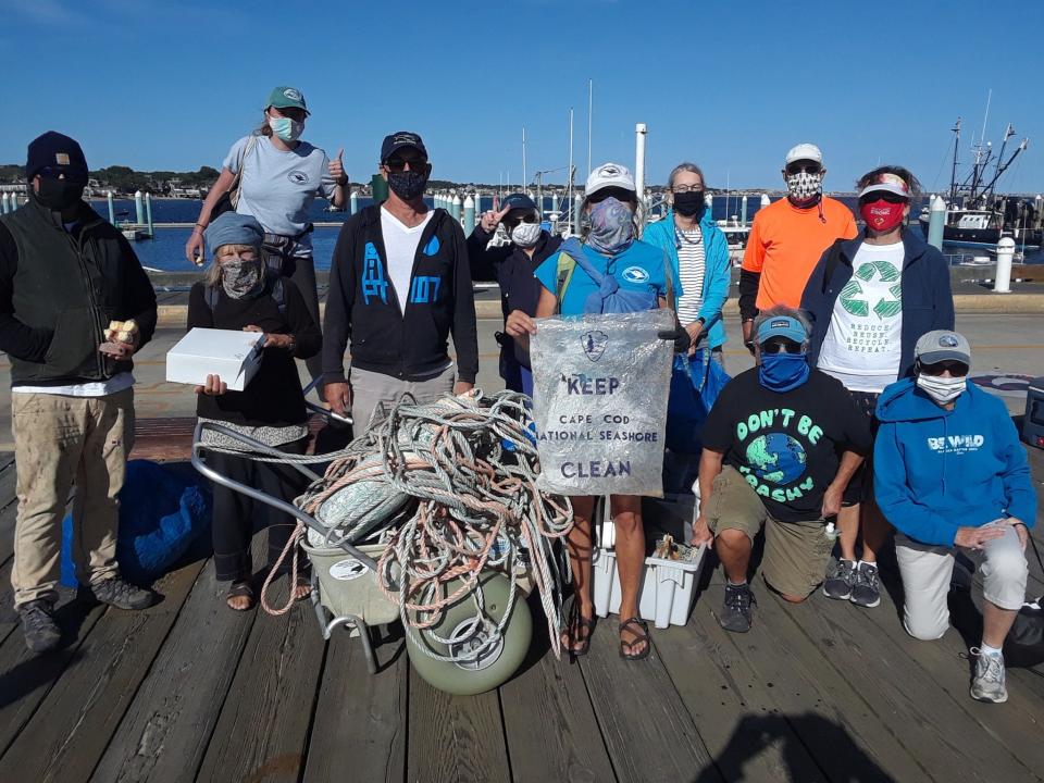 Volunteers with the Center for Coastal Studies in Provincetown hold up what was collected during a beach cleanup in 2020.