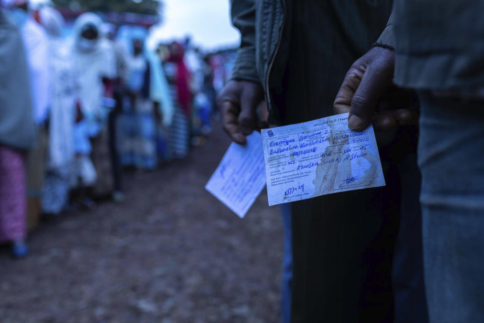 Ethiopians line up to cast vote in the general election in his home town of Beshasha, in the Oromia region of Ethiopia, Monday, June 21, 2021. Ethiopians are voting in a landmark election that is the centerpiece of a reform drive by Prime Minister Abiy Ahmed but is overshadowed by the situation in the country's war-hit Tigray region. (AP Photo/Mulugeta Ayene).