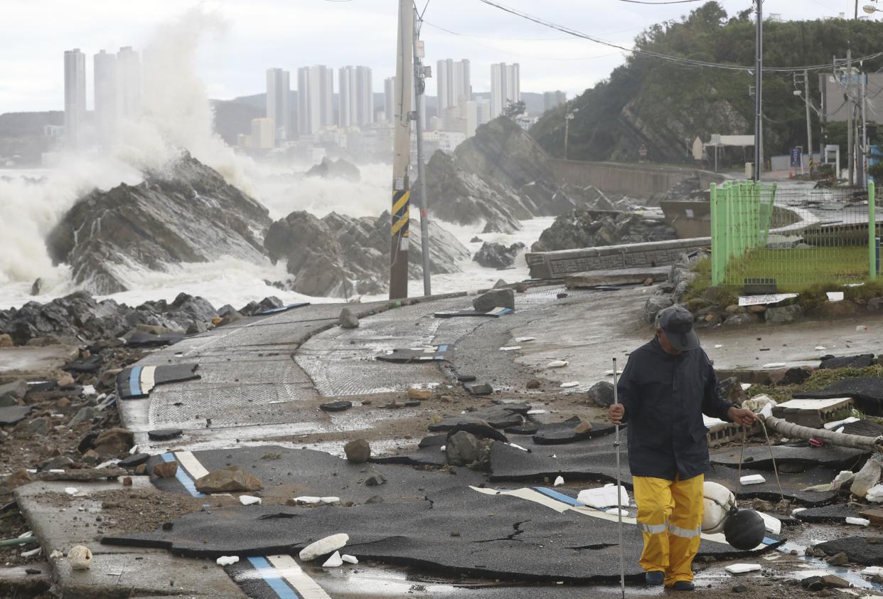 A road is damaged as waves hit a shore in Ulsan, South Korea, on Sept. 6. 