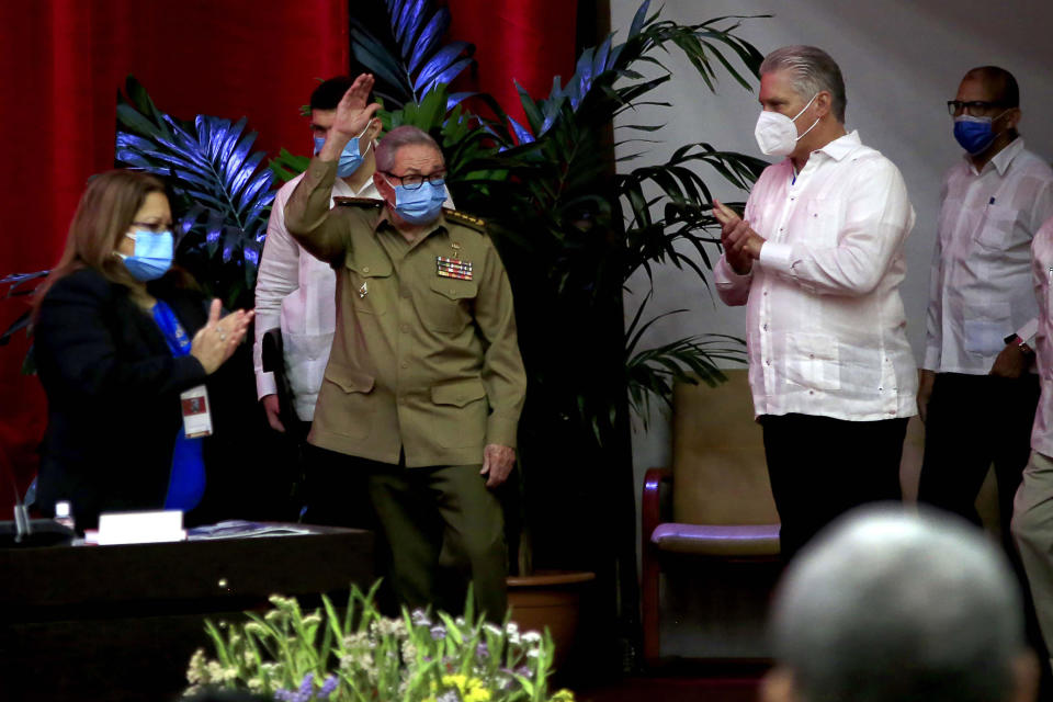 Raul Castro, first secretary of the Communist Party and former president, waves to members at the VIII Congress of the Communist Party of Cuba's opening session, as Cuban President Miguel Diaz-Canel, right, applauds at the Convention Palace, in Havana, Cuba, Friday, April 16, 2021. (Ariel Ley Royero/ACN via AP)