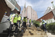 Quarantine officials disinfect as a precaution against the new coronavirus in Suwon, South Korea, Monday, June 1, 2020. South Korea is reporting a steady rise in cases around the capital as officials push to require entertainment venues to register their customers with smartphone QR codes so they could be easily located when needed. (Hong Ki-won/Yonhap via AP)