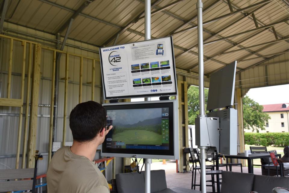 A 42nd Air Base Wing airman plays Toptracer golf at Range 42 during a Toptracer soft opening May 18, 2022. The driving range has modernized the golfing experience through Toptracer technology that will provide six globally connected bays with a wide variety of games for Airmen, Guardians, and families.