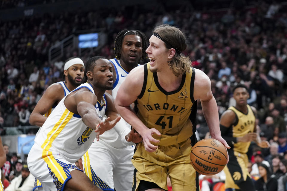 Toronto Raptors forward Kelly Olynyk (41) protects the ball from Golden State Warriors forward Jonathan Kuminga during the second half of an NBA basketball game Friday, March 1, 2024, in Toronto. (Arlyn McAdorey/The Canadian Press via AP)