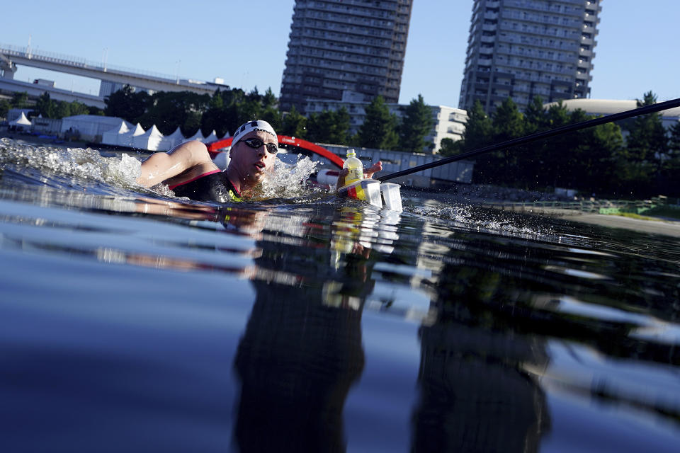 Florian Wellbrock, of Germany, stops for a drink at a feeding station during the men's marathon swimming event at the 2020 Summer Olympics, Thursday, Aug. 5, 2021, in Tokyo. (AP Photo/David Goldman)