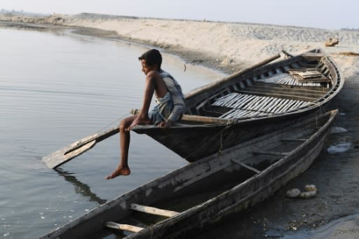 A boy sits on a boat in Barpeta village in Assam, where many residents were left off a newly compiled register of citizens