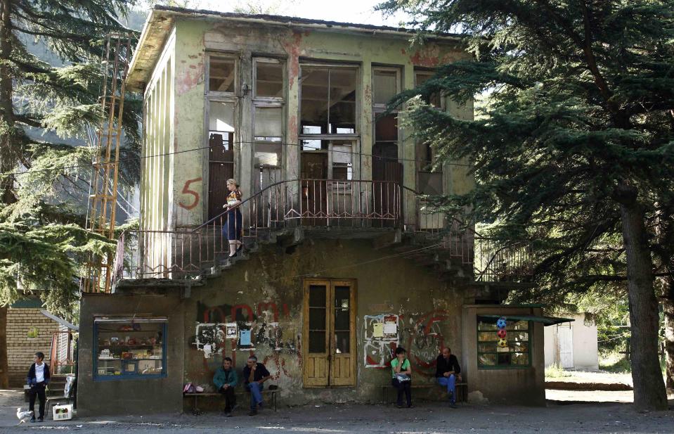 People sit in front of a cable car station in the town of Chiatura