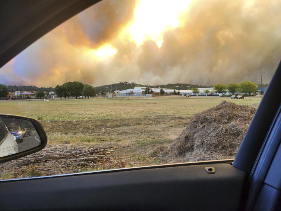 In this photo provided by Belinda Bukovitz, smoke rises from fires in Ruidoso, N.M., Monday, June 17, 2024. Thousands of southern New Mexico residents fled the mountainous village as a wind-whipped wildfire tore through homes and other buildings. (Belinda Bukovitz via AP)