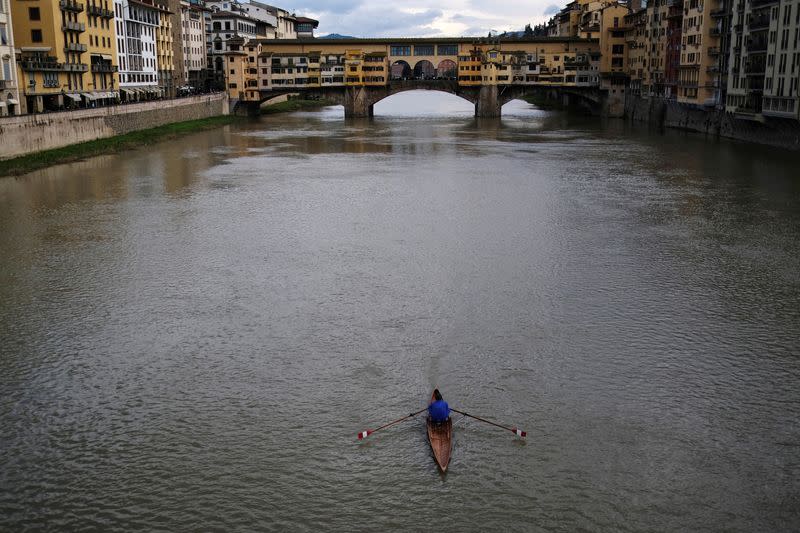 FILE PHOTO: A man rows his canoe on the Arno river in front of Ponte Vecchio (Old Bridge) in Florence, Italy