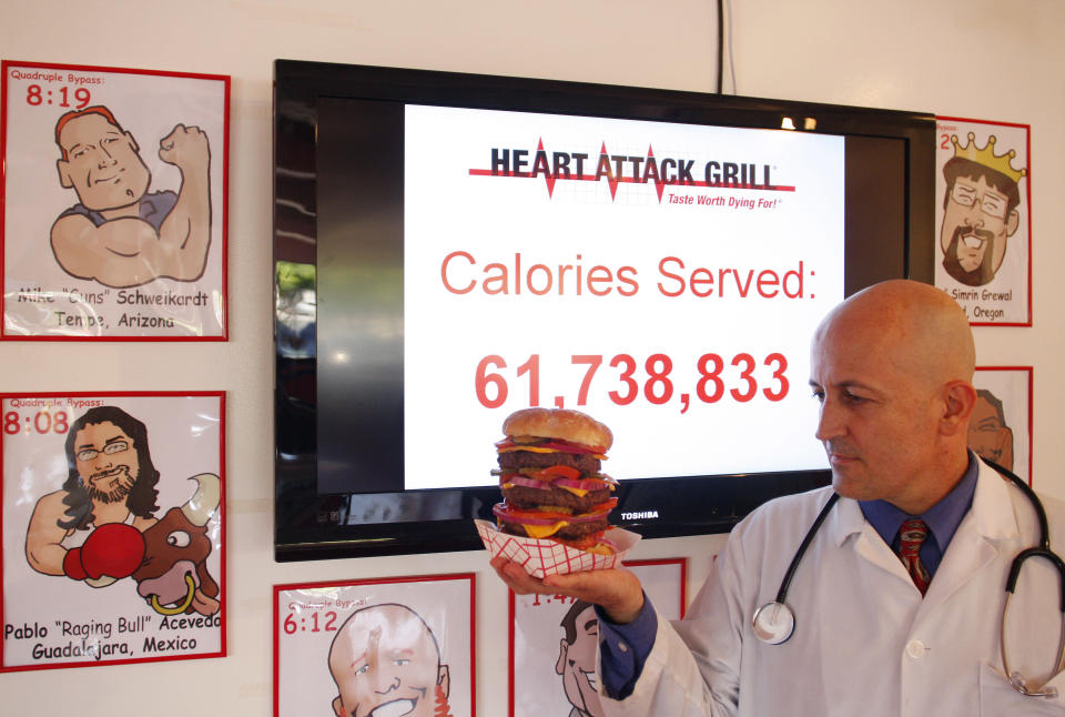 Heart Attack Grill owner Jon poses with a quadruple bypass cheese burger in Chandler, Arizona June 17, 2009. The restaurant is known for its hospital theme and triple and quadruple bypass burgers. REUTERS/Joshua Lott