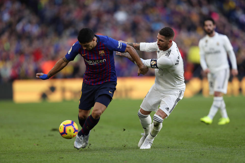 Barcelona forward Luis Suarez, left, and Real defender Sergio Ramos fight for the ball during the Spanish La Liga soccer match between FC Barcelona and Real Madrid at the Camp Nou stadium in Barcelona, Spain, Sunday, Oct. 28, 2018. (AP Photo/Manu Fernandez)