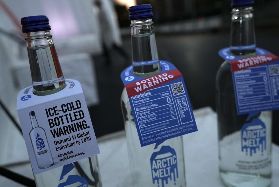 Bottles containing melted ice water on display close to where an iceberg delivered by members of Arctic Basecamp was placed on show near the COP26 U.N. Climate Summit in Glasgow, Scotland, Friday, Nov. 5, 2021. The four ton block of ice, originally part of a larger glacier, was brought from Greenland to Glasgow by climate scientists from Arctic Basecamp as a statement to world leaders of the scale of the climate crisis and a visible reminder of what Arctic warming means for the planet. (AP Photo/Alastair Grant)