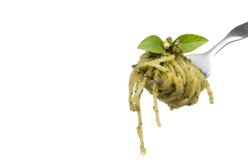 Spaghetti with homemade pesto Genovese sauce on fork, isolated on white background