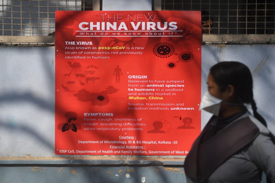 A security staff wearing a face mask to prevent the spread of the SARS-like virus walks past an information sign on the virus at the Infectious Disease and Beliaghata General Hospital, where four people with symptoms of the virus are kept in quarantine at an isolation ward, in Kolkata on February 3, 2020. - India's health ministry on February 2 confirmed the country's second case, which like the first, is in the southern state of Kerala. The ministry said the new case was being treated in isolation at a hospital. (Photo by Dibyangshu SARKAR / AFP) (Photo by DIBYANGSHU SARKAR/AFP via Getty Images)