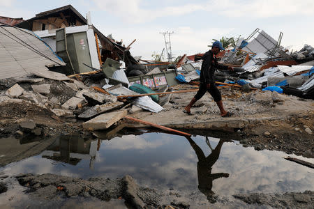 FILE PHOTO: A man walks at Petobo neighbourhood which was hit by earthquake and liquefaction in Palu, Central Sulawesi, Indonesia, October 9, 2018. REUTERS/Darren Whiteside