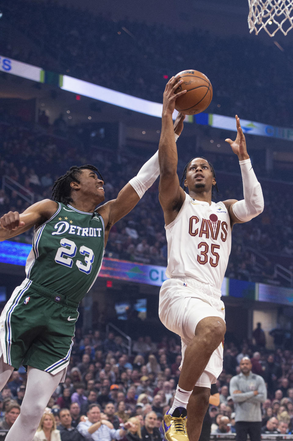 Detroit Pistons' Jaden Ivey (23) fouls Cleveland Cavaliers' Isaac Okoro (35) during the first half of an NBA basketball game in Cleveland, Saturday, March 4, 2023. (AP Photo/Phil Long)