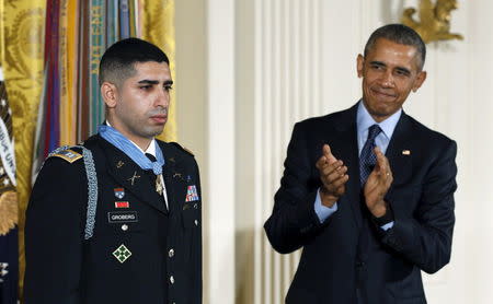 President Barack Obama applauds retired U.S. Army Captain Florent Groberg, 32, after presenting him with the Medal of Honor during a ceremony at the White House in Washington November 12, 2015. REUTERS/Kevin Lamarque