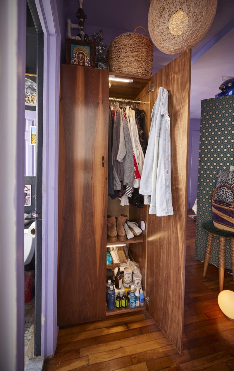 Clothes organized in wooden armoire.