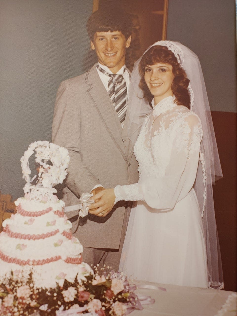 Rod and Debra McCune pose for the ceremonial cake-cutting photo at their wedding in 1982 in Newcomerstown. The late Rod Smith, of Rod's Donut Shop in Uhrichsville, made the cake after the first one collapsed.