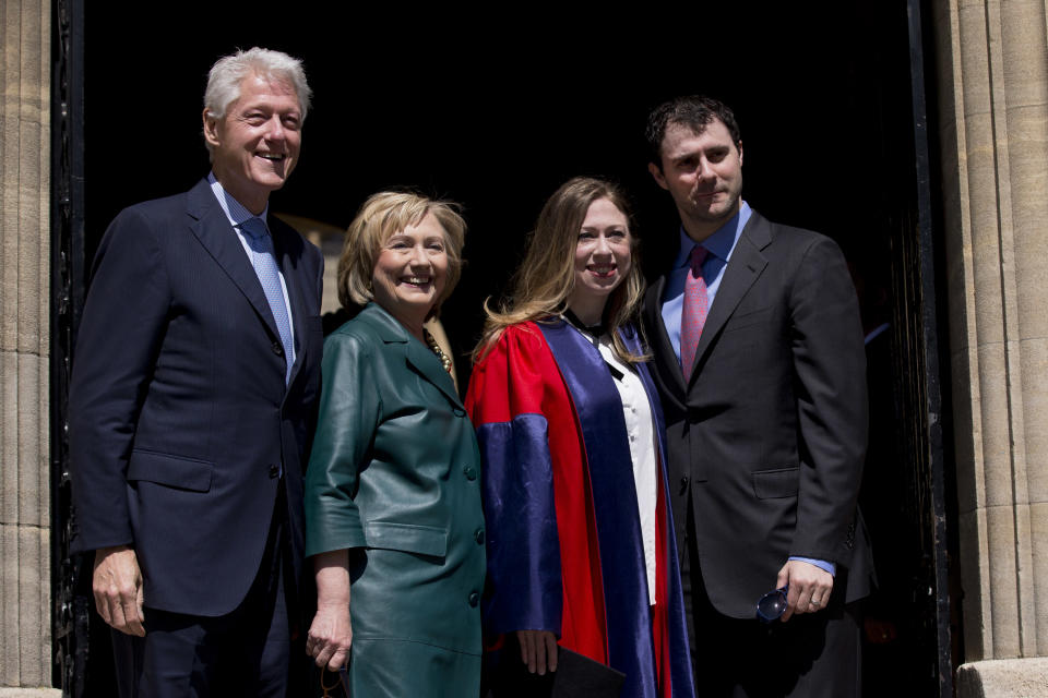 Former U.S. President Bill Clinton, left, and his wife former Secretary of State Hillary Rodham Clinton, second left, pose for photographers with their daughter Chelsea, second right, and her husband Marc Mezvinsky, after they all attended Chelsea's Oxford University graduation ceremony at the Sheldonian Theatre in Oxford, England, Saturday, May 10, 2014. Chelsea Clinton received her doctorate degree in international relations on Saturday from the prestigious British university. Her father was a Rhodes scholar at Oxford from 1968 to 1970. The graduation ceremony comes as her mother is considering a potential 2016 presidential campaign. (AP Photo/Matt Dunham)