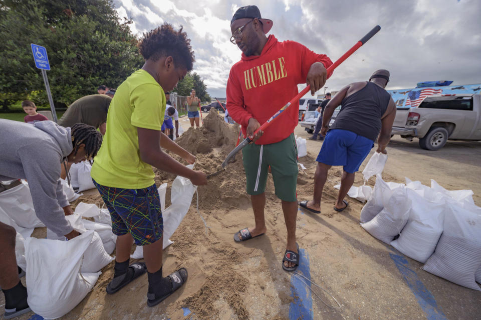 Jawan Williams shovels sand for a sandbag held by his son Jayden Williams, before landfall of Hurricane Ida at the Frederick Sigur Civic Center in Chalmette, La., which is part of the Greater New Orleans metropolitan area, Saturday, Aug. 28, 2021. The storm is expected to bring winds as high as 140 mph when it slams ashore late Sunday. (AP Photo/Matthew Hinton)