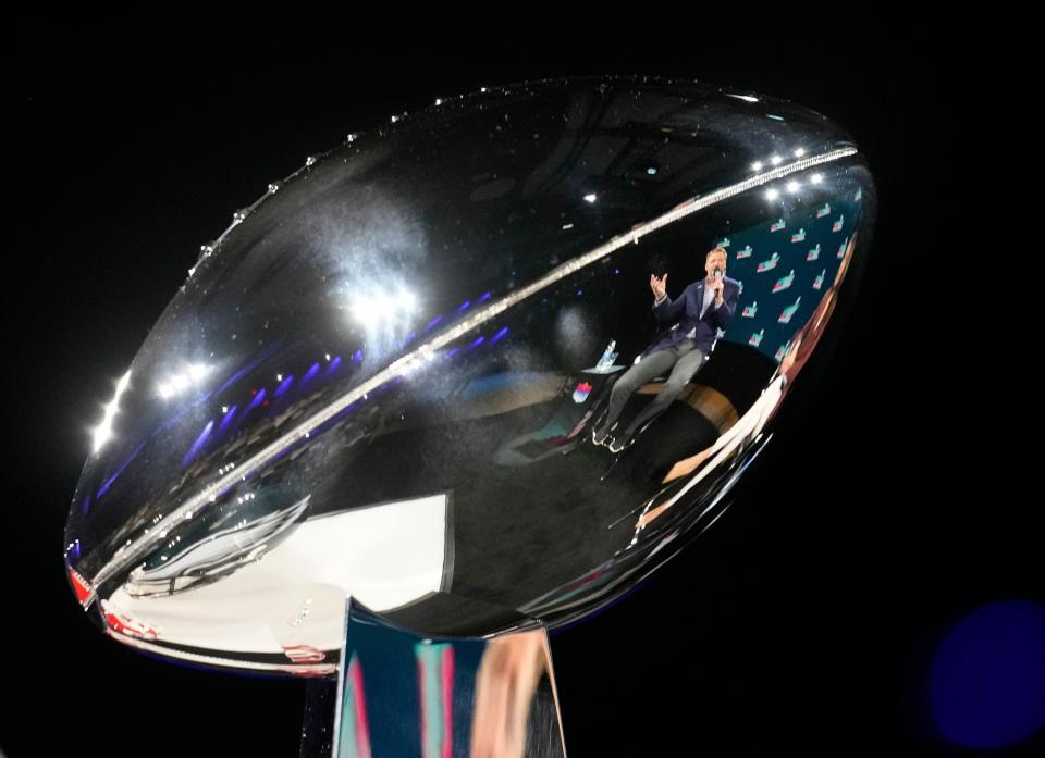 Reflected in the Vince Lombardi Trophy, NFL commissioner Roger Goodell answers a question during a news conference at the Phoenix Convention Center on Feb 8, 2023.