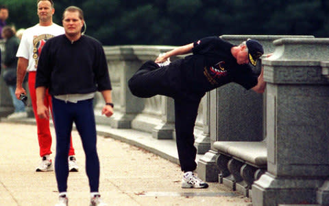 Bill Clinton, accompanied by Secret Service agents, stretches near the Lincoln Memorial in 1996  - Credit: Reuters