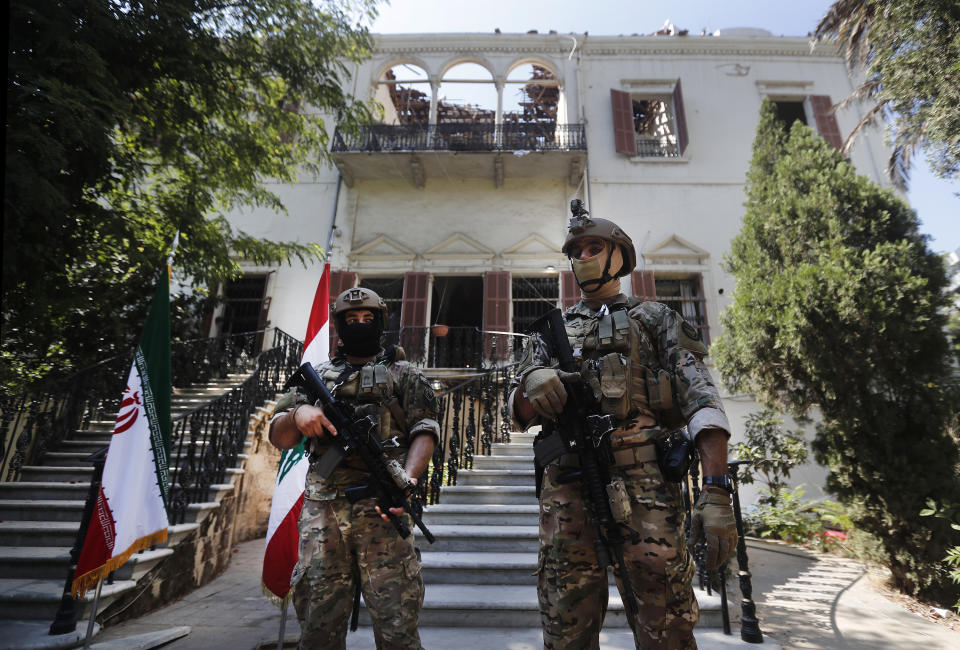 Lebanese special forces soldiers who work to protect the visit of Iranian Foreign Minister Mohammad Javad Zarif, stand guard outside the Lebanese foreign ministry damaged by last week's explosion that his the seaport of Beirut, Lebanon, Friday, Aug. 14, 2020. (AP Photo/Hussein Malla)