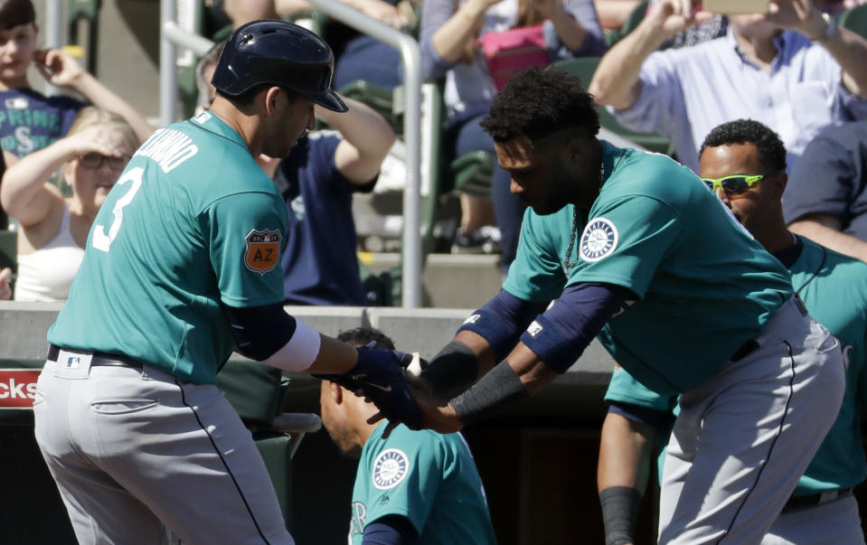 Seattle Mariners' Mike Zunino, left, celebrates after a home run with Robinson Cano during second inning at a spring baseball game against the Colorado Rockies in Scottsdale, Ariz., Saturday, March 4, 2017. (AP Photo/Chris Carlson)