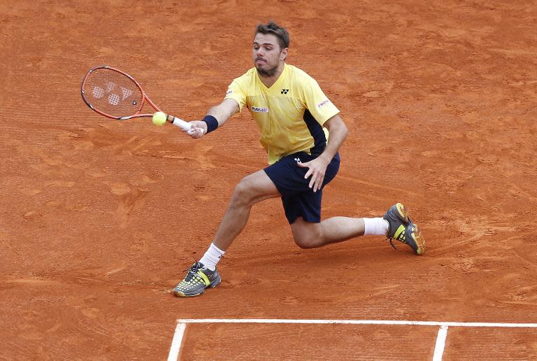 Stanislas Wawrinka of Switzerland hits a return to his compatriot Roger Federer during their Monte Carlo ATP Masters Series Tournament final, in Monaco, on April 20, 2014