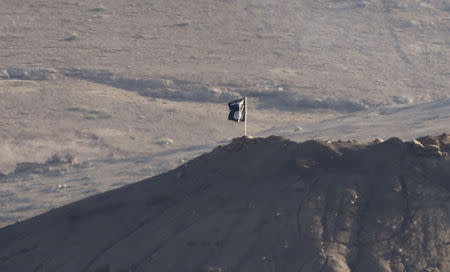 A black flag belonging to the Islamic State is seen near the Syrian town of Kobani, as pictured from the Turkish-Syrian border near the southeastern town of Suruc in Sanliurfa province, October 6, 2014. REUTERS/Umit Bektas