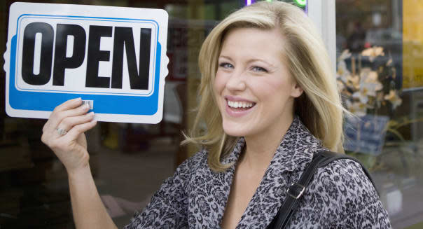 Smiling woman with an open sign