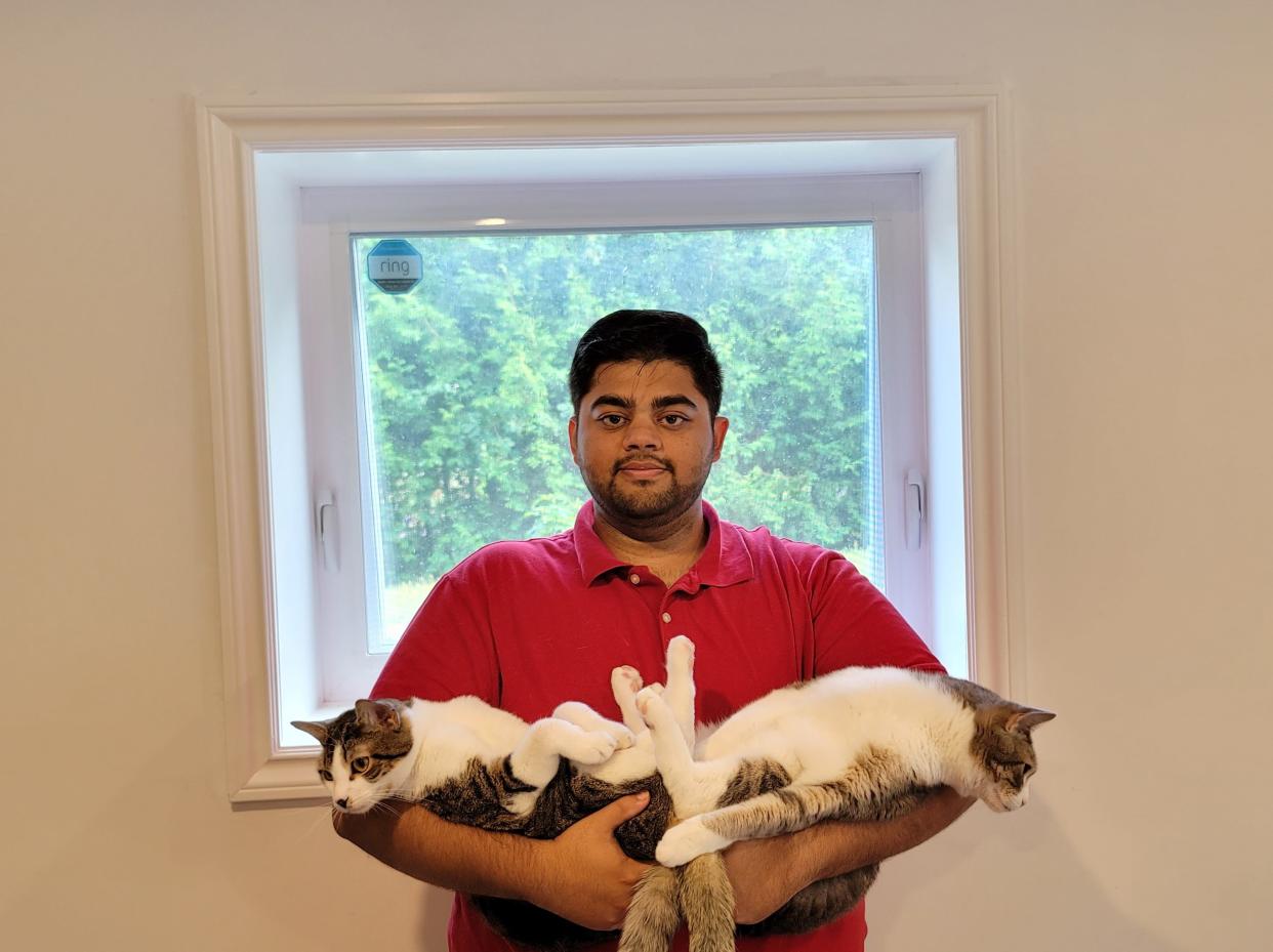 Abbas Zoeb holding his two cats.