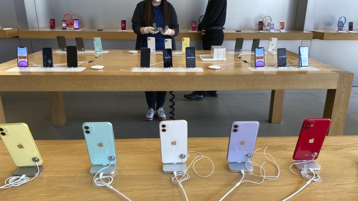 Mitarbeiter mit Mundschutz arbeitet in einem Apple Store in Peking.