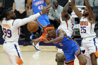 Oklahoma City Thunder guard Shai Gilgeous-Alexander (2) passes between Phoenix Suns forward Mikal Bridges (25), center Deandre Ayton (22) and forward Jae Crowder (99) during the first half of an NBA basketball game, Wednesday, Jan. 27, 2021, in Phoenix. (AP Photo/Matt York)