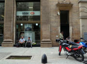 People sit outside a bank in Buenos Aires' financial district, Argentina October 18, 2018. Picture taken October 18, 2018. REUTERS/Marcos Brindicci