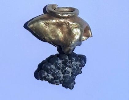 A tassel or earring made of gold and silver was found amid a layer of ashen material linked to the Babylonian conquest of Jerusalem in the sixth century BCE. (Mount Zion Archaeological Expedition / Rafi Lewis)
