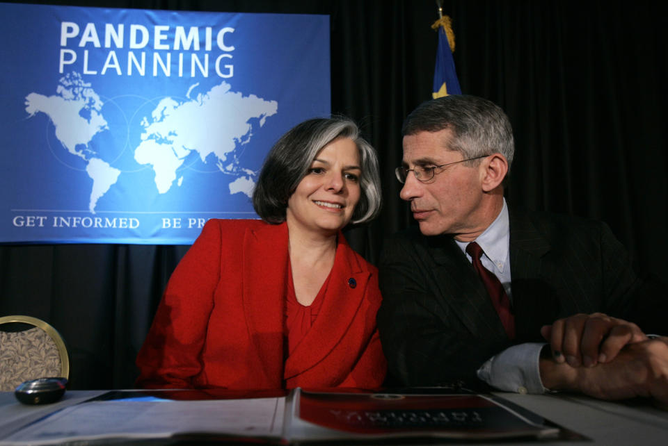 FILE - Julie Gerberding, director, Centers for Disease Control and Prevention, left, talks with Anthony Fauci, director, National Institute of Allergy and Infectious Diseasee, National Institutes of Health, during a meeting in Washington, Dec. 5, 2005, of state and city officials to press them to start planning for a bird flu or super-flu pandemic. Fauci steps down from a five-decade career in public service at the end of the month, one shaped by the HIV pandemic early on and the COVID-19 pandemic at the end. (AP Photo/Susan Walsh, File)