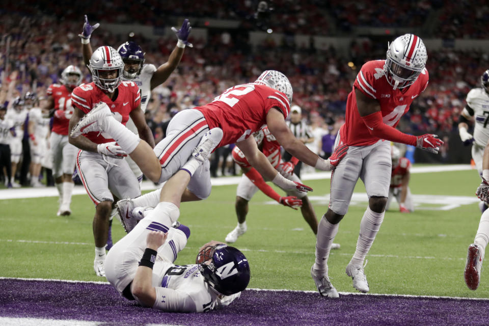 Northwestern quarterback Clayton Thorson, bottom, falls into the end zone at the end of a touchdown during the second half of the Big Ten championship NCAA college football game against Ohio State, Saturday, Dec. 1, 2018, in Indianapolis. (AP Photo/Michael Conroy)